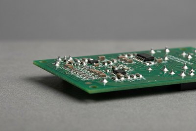 Bare printed circuit board with surface-mount components on a workbench